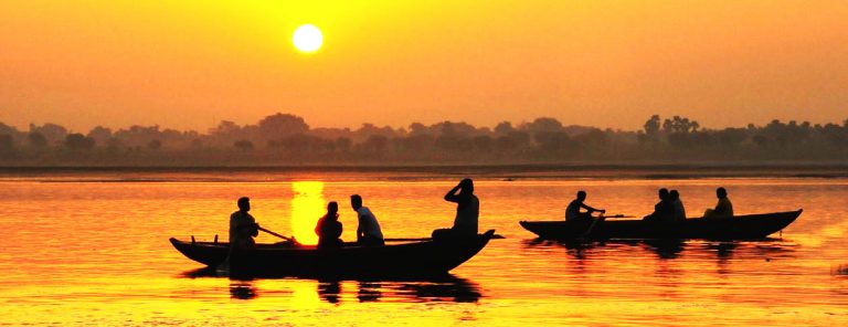 Contact Un coucher de soleil sur le Gange avec des bateaux indiens.